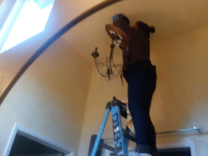 Electrician installing a chandelier in a Winter Haven residence